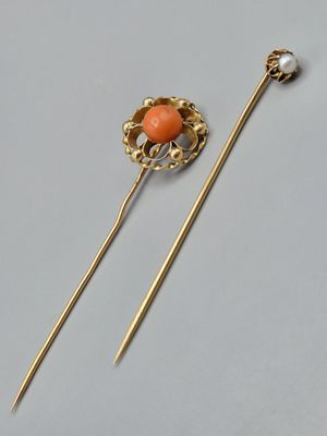 une image représentant une paire d'épingles à cheveux aux couleurs or et corail