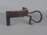 a small metal object with a handle on a white surface