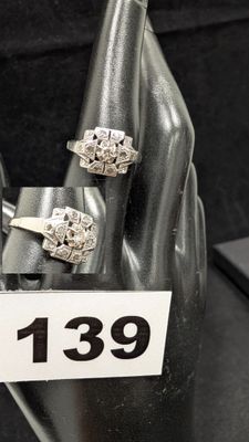 trois bagues en argent exposées dans une vitrine, accompagnées d'une étiquette de prix
