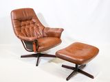 fauteuil et repose-pieds en cuir marron sur fond blanc, avec une toile de fond blanche