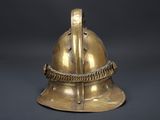 an old brass helmet with a rope around it on a black background