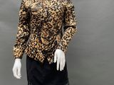 a mannequin wearing a leopard print top and black skirt