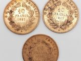 trois types différents de pièces d'or sur une surface blanche