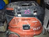 an orange and black lawn mower sitting on top of a floor next to a pile of books