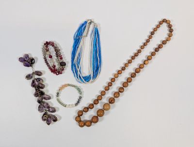 a lot of beads and bracelets on a white surface
