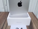 an apple computer sitting on top of a white box on a wooden table