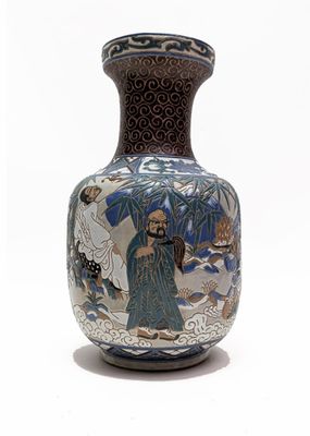 a vase with a painting on it on a white surface