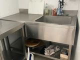un évier en acier inoxydable dans une cuisine, à côté d'un plan de travail