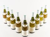 six bottles of wine are lined up in a row on a white surface