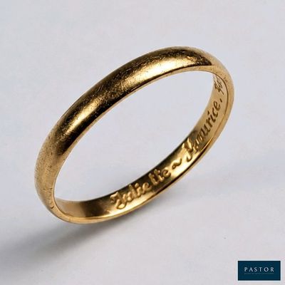 gros plan d'une bague en or sur une surface blanche