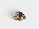 a close up of a gold ring with a blue stone