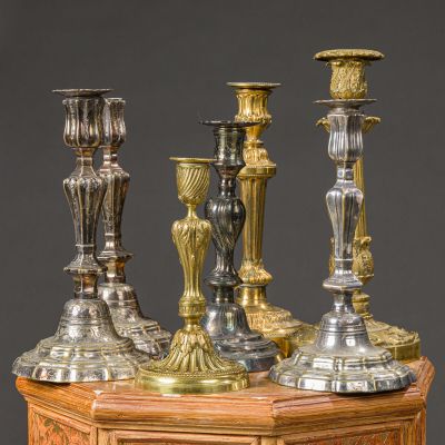 three silver candles are sitting on top of a wooden table