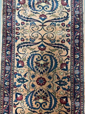 an antique persian rug with a floral design on a beige ground