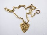a close up of a gold necklace with a heart on it
