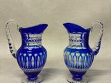 paire de vases en verre bleu avec des anses, sur fond blanc