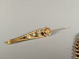 an image of a close up of a gold hair pin