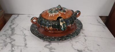 a brown and green bowl with a lid on a marble table