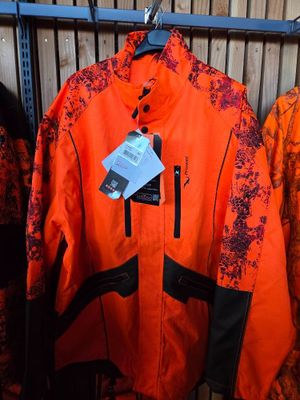 orange and black jacket hanging on a rack in a store