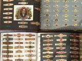 two opened cigar boxes with cigar labels on them sitting on a bed