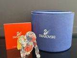 une figurine d'éléphant en verre posée à côté d'une boîte bleue