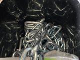 un récipient contenant tout un tas de crochets métalliques