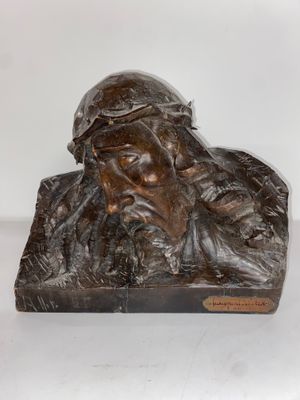 une statue en bronze représentant un homme barbu coiffé d'un chapeau