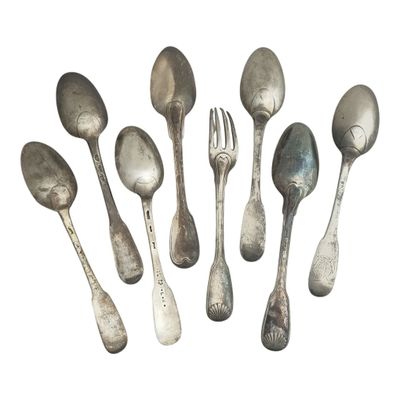 six cuillères en argent et une fourchette sont disposées en cercle