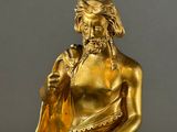 gold statue of a man with a pipe in his hand