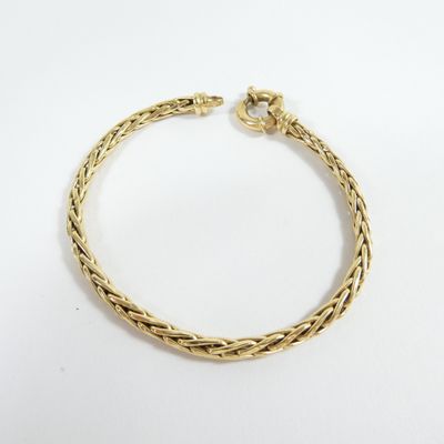 a gold bracelet with a braid design on a white background