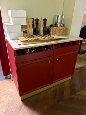 une armoire rouge avec un plan de travail blanc dans une pièce