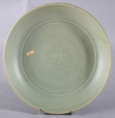une assiette verte sur laquelle est posée une étiquette, posée sur une table