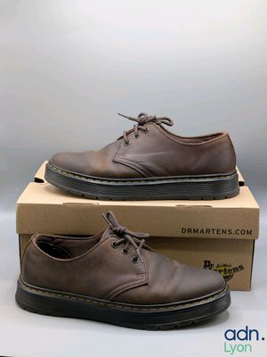 des chaussures Dr Martens dans une boîte posée sur une surface blanche