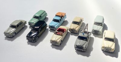 plusieurs petites voitures sont alignées sur une surface blanche