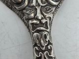 a silver spoon with a face on it on a table