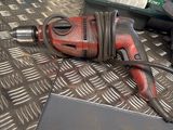 an image of a corded drill on the floor
