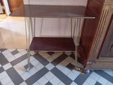 une petite table surmontée d'une étagère, placée dans un coin de la pièce