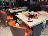 de nombreuses chaises et tables dans un restaurant, avec un pot-au-feu sur chaque table
