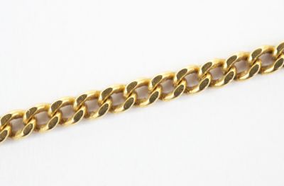 a close up of a gold chain on a white surface