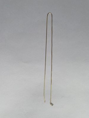 un collier en argent dont l'extrémité est ornée d'une longue chaîne