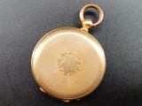 a gold pocket watch on a black surface