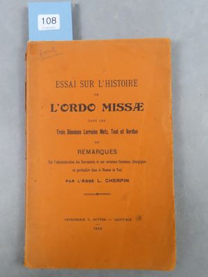 un livre orange posé sur une table, à côté d'une étiquette bleue