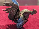 a figurine of a bird on a red surface