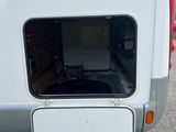 the rear end of a white camper with the door open