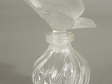 a clear glass bottle with a bird on it