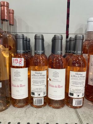 bottles of wine are lined up on a shelf in a store