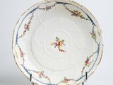 a white plate with flowers on it on a stand