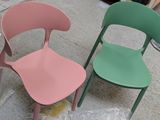 two chairs sitting next to each other on the ground