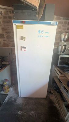 un réfrigérateur blanc dans une pièce aux murs en briques
