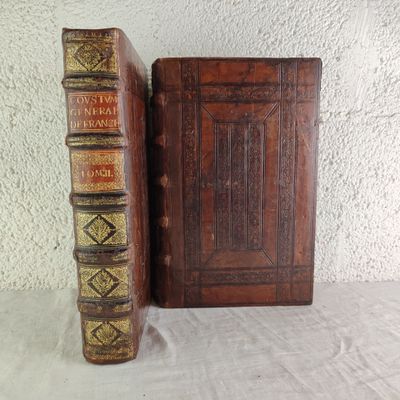 two old books sitting on a table next to each other