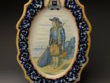 une assiette bleue et blanche sur laquelle est représenté un homme